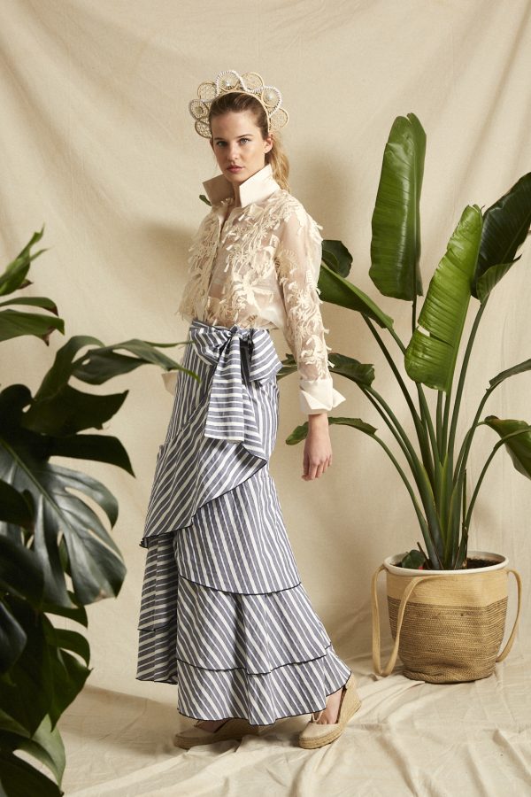 Camisa de seda 100%, tiene un gran trabajo de bordado a mano, unas palmeras tropicales en color crudo que evocan a la temporada de calor con una elegancia suprema.