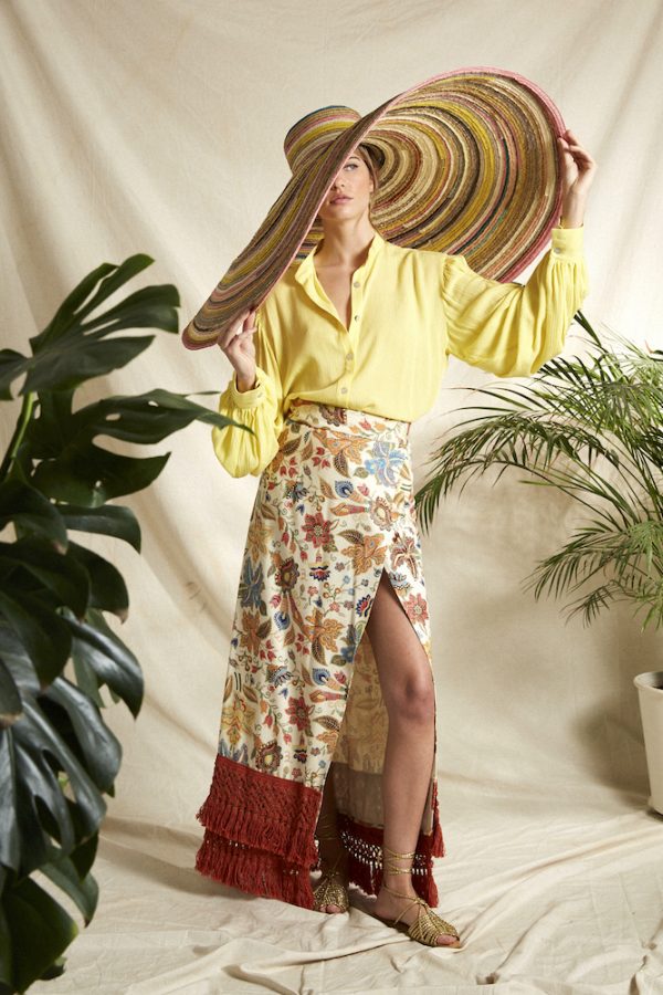 Falda tipo pareo, tejido de seda, con cinta ajustable, un print de flores alegres y multicolor además unos flecos en color naranja